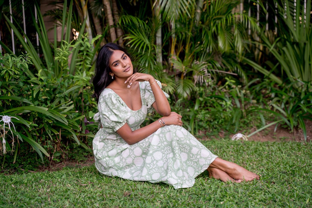 Girl sitting on grass posing in green cotton maxi dress